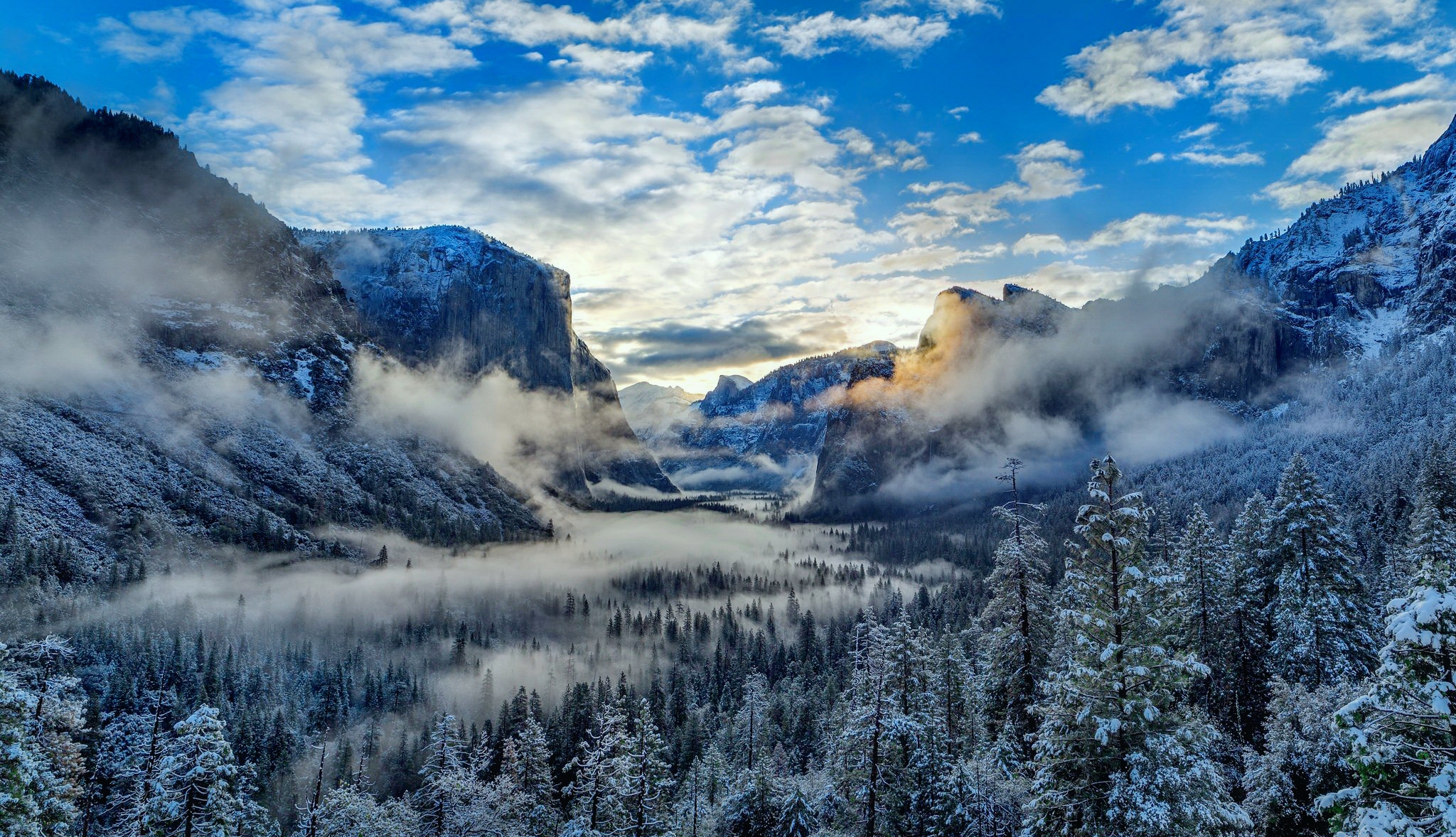Скачать картинку Зима, Облака, Снег, Гора, Лес, Туман, Ландшафт, Земля/природа в телефон бесплатно.