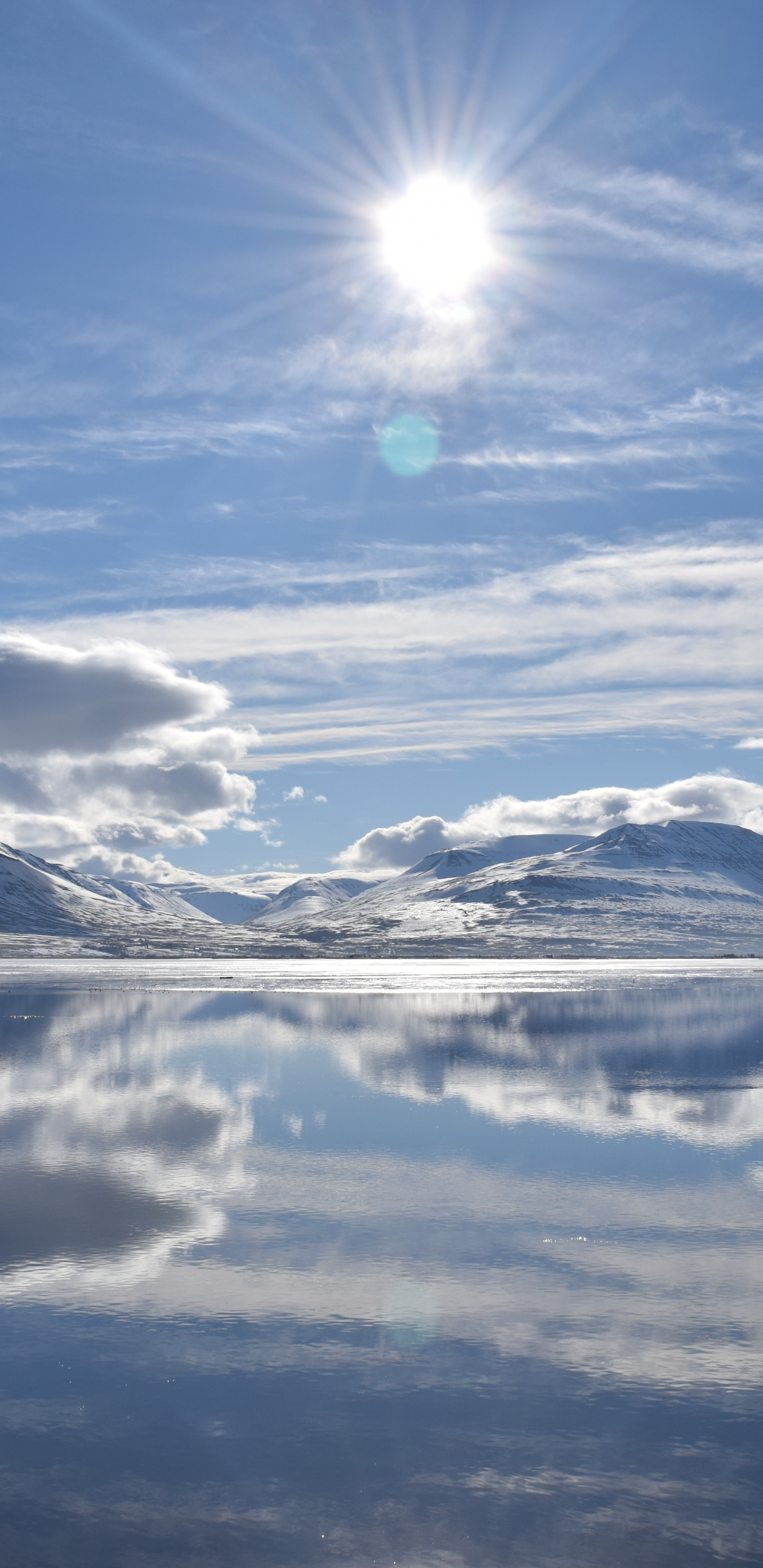 Скачать картинку Пейзаж, Зима, Вода, Солнце, Облака, Озеро, Отражение, Облако, Исландия, Ландшафт, Земля/природа в телефон бесплатно.