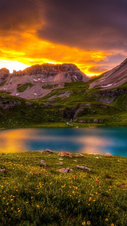 Download mobile wallpaper Sunset, Sky, Lakes, Mountain, Lake, Flower, Earth, Field, Cloud, Orange (Color) for free.