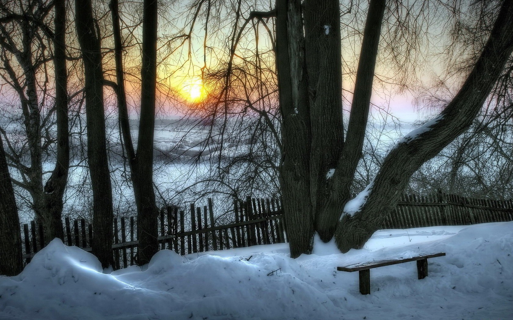 Скачать картинку Зима, Снег, Дерево, Изгородь, Скамья, Фотографии, Закат Солнца в телефон бесплатно.
