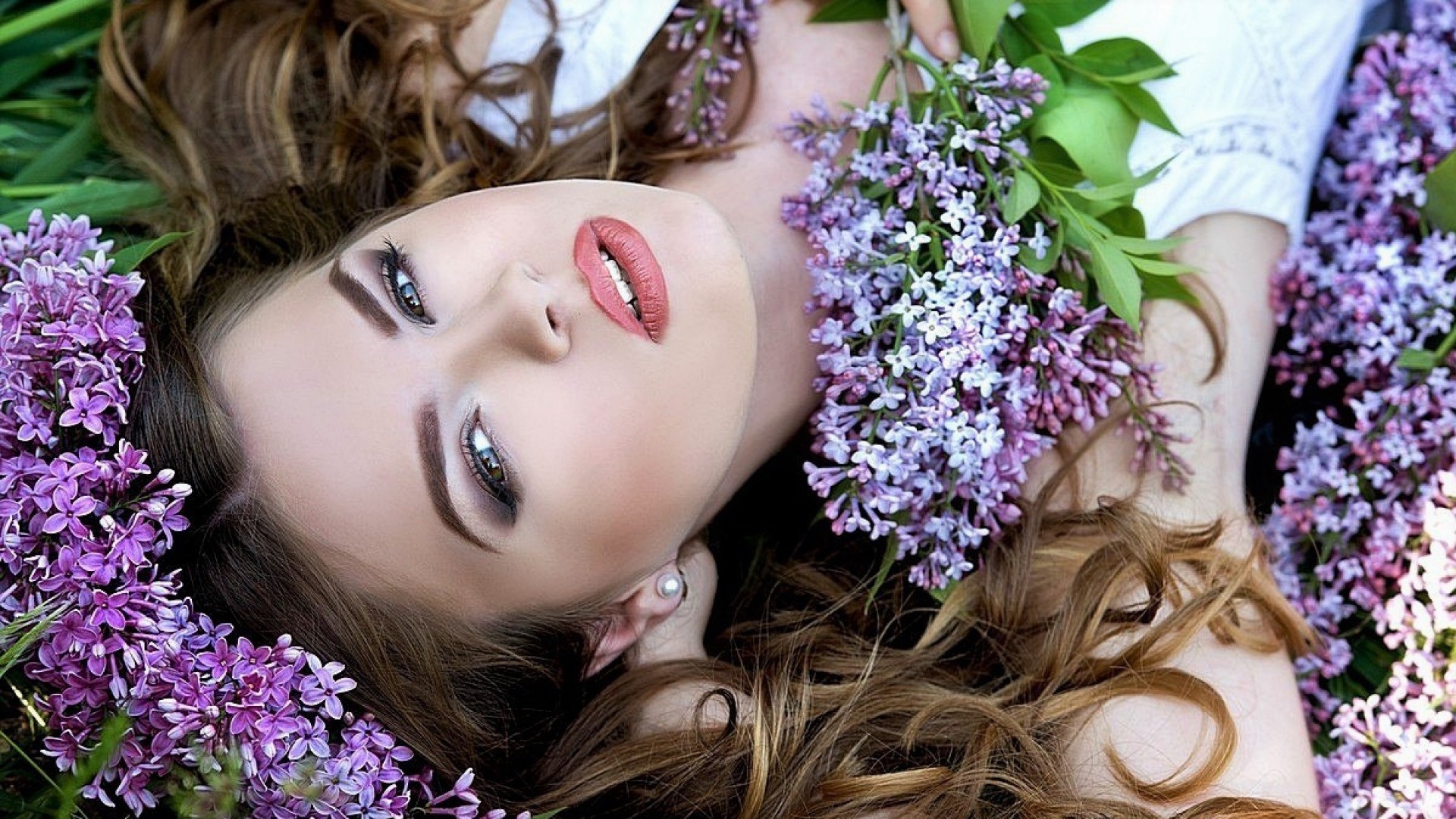 Download mobile wallpaper Lilac, Flower, Face, Brunette, Model, Women, Lipstick, Lying Down for free.