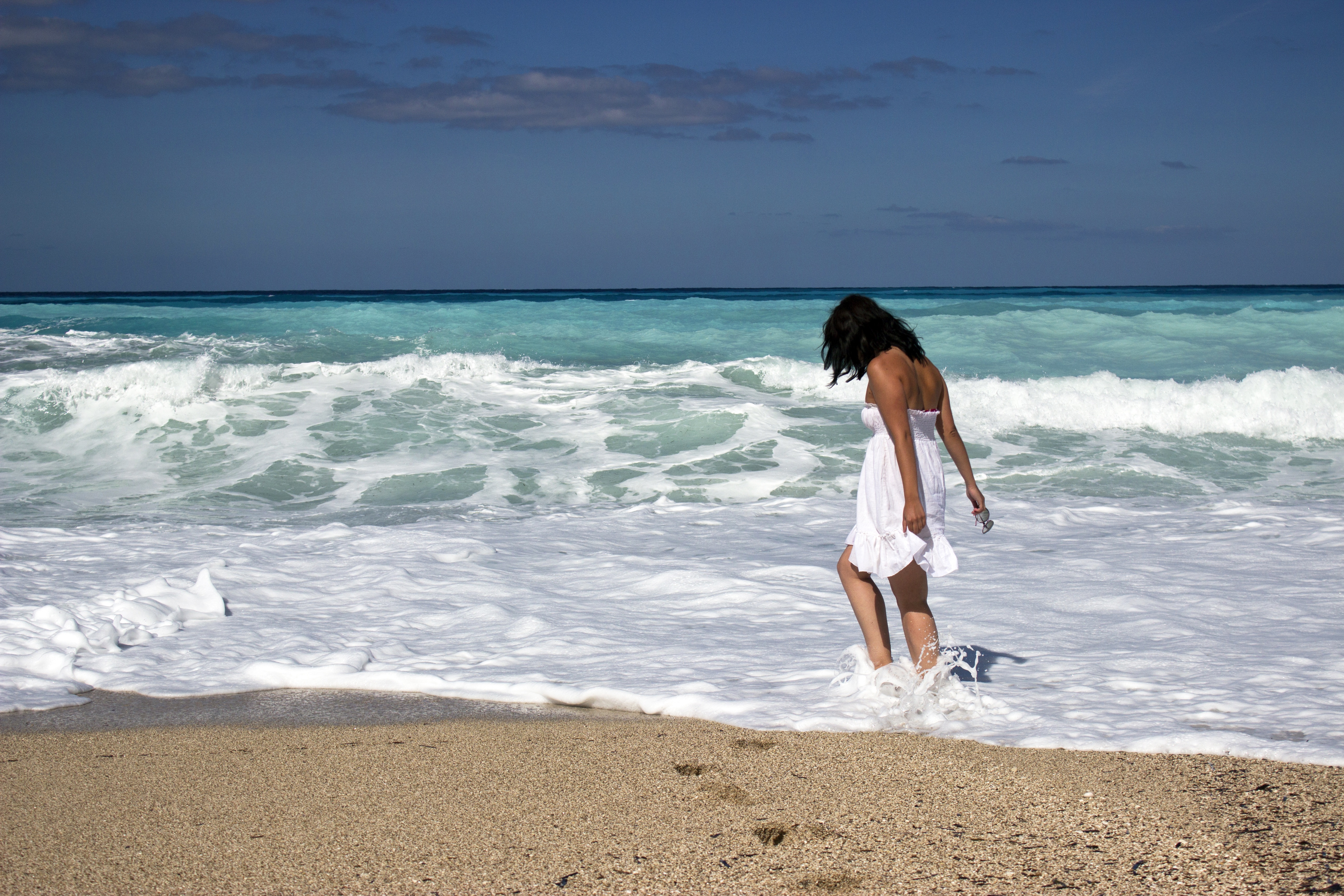 Скачать картинку Пляж, Песок, Горизонт, Океан, Волна, Женщины, Задний в телефон бесплатно.