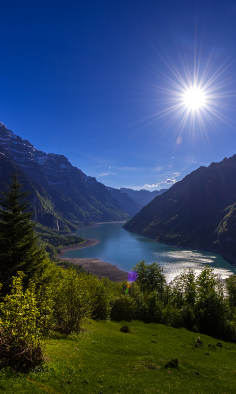 Скачать картинку Пейзаж, Солнце, Гора, Озеро, Швейцария, Земля/природа в телефон бесплатно.