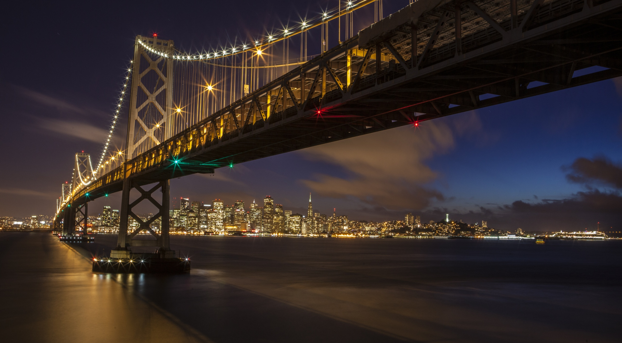 Скачать картинку Мосты, Ночь, Город, Свет, Сан Франциско, Бэй Бридж, Сделано Человеком в телефон бесплатно.