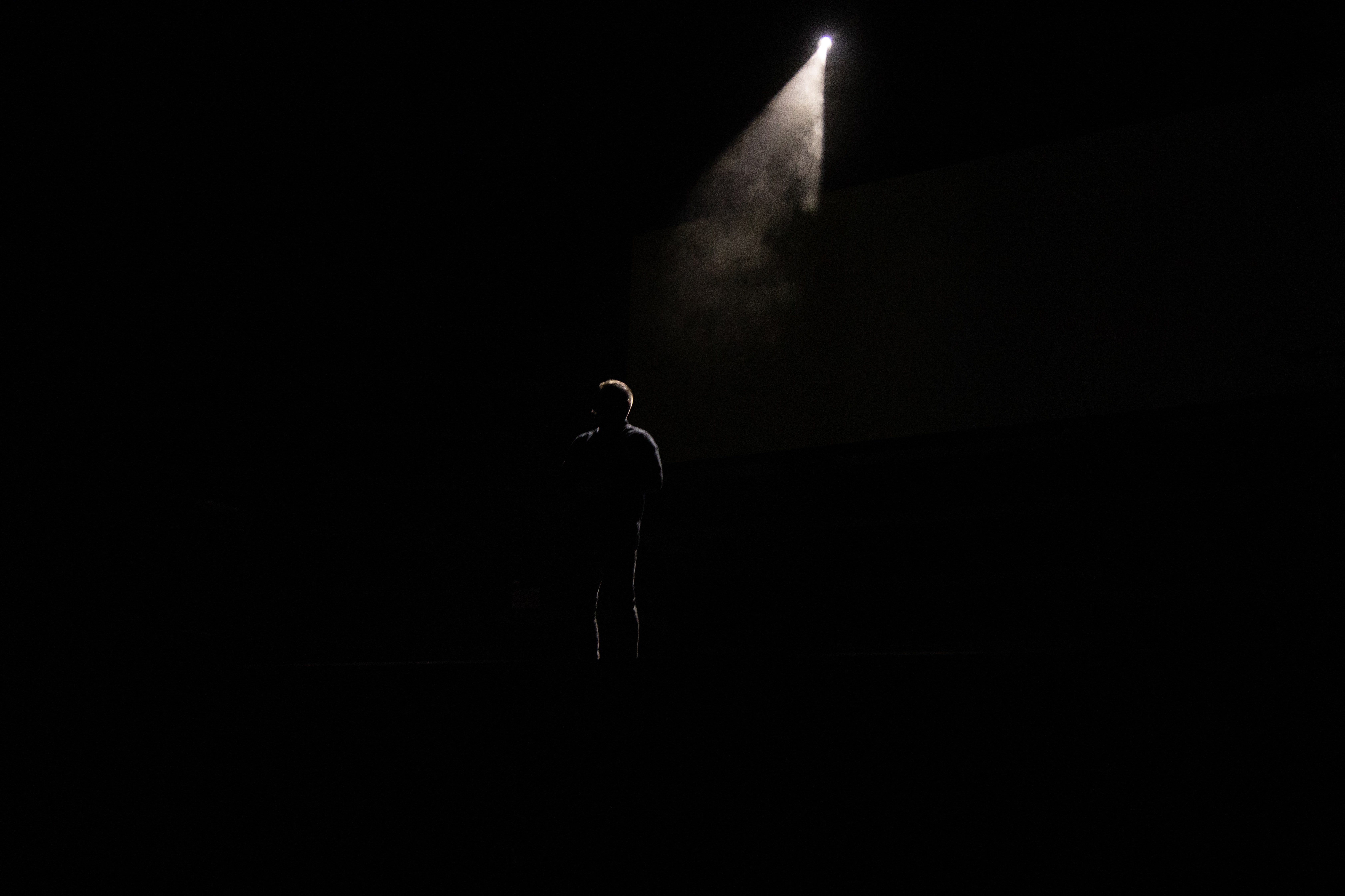 Download mobile wallpaper Ray, Person, Silhouette, Loneliness, Shine, Light, Human, Dark for free.