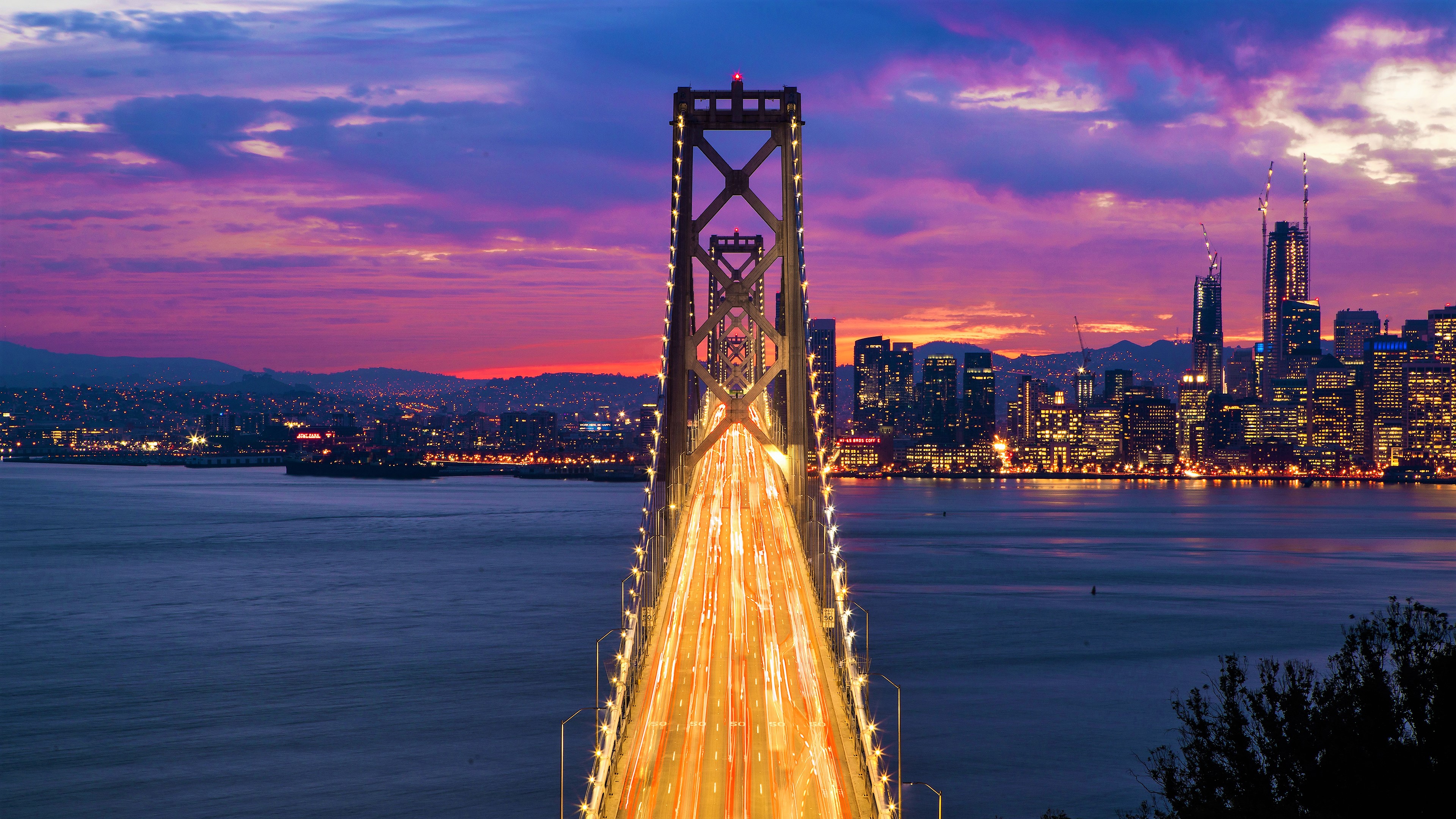 Скачать картинку Мосты, Закат, Свет, Мост, Калифорния, Сан Франциско, Бэй Бридж, Сделано Человеком, Замедленная Киносъёмка в телефон бесплатно.