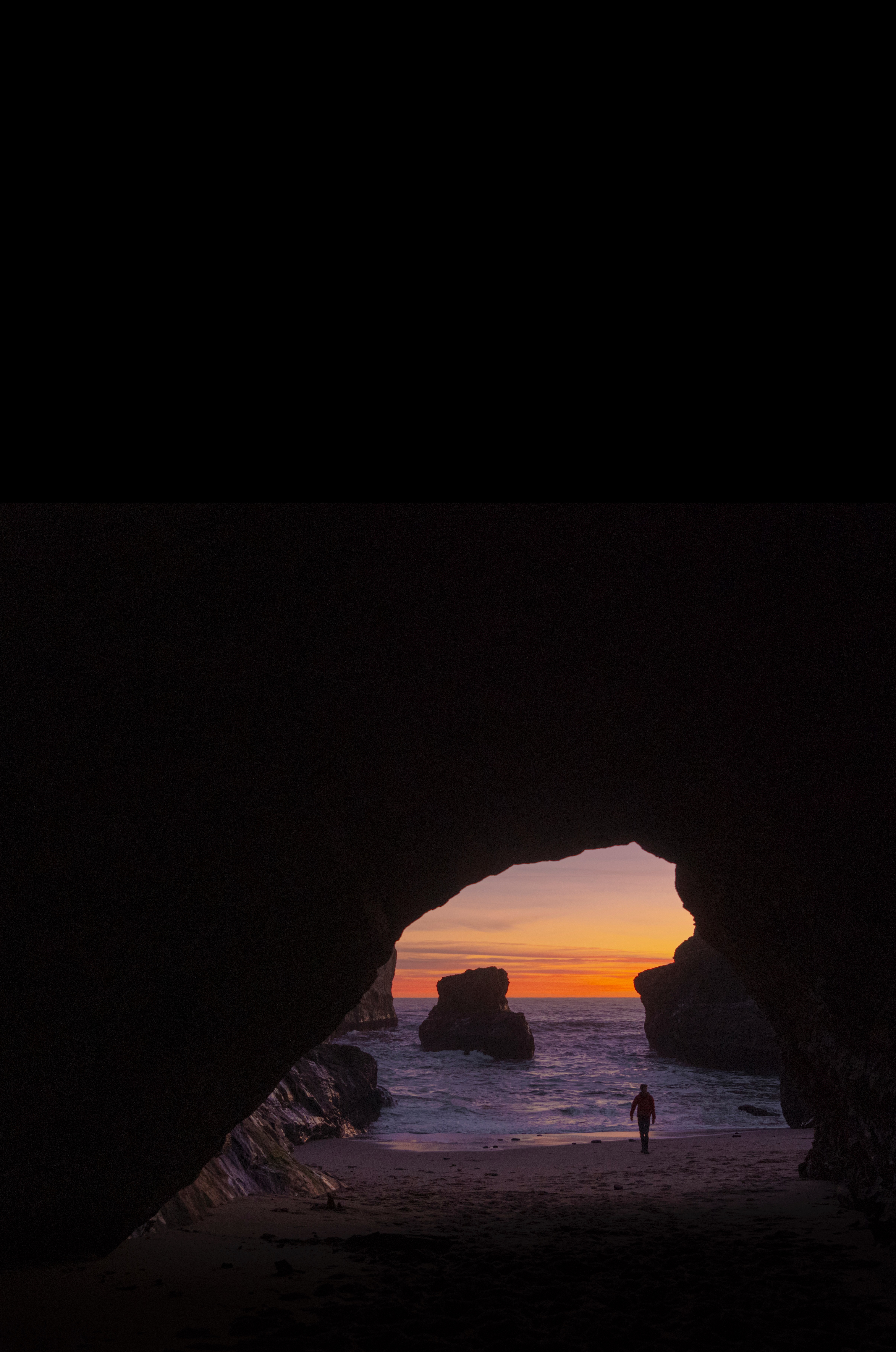 Download mobile wallpaper Rocks, Sunset, Silhouette, Cave, Water, Dark for free.