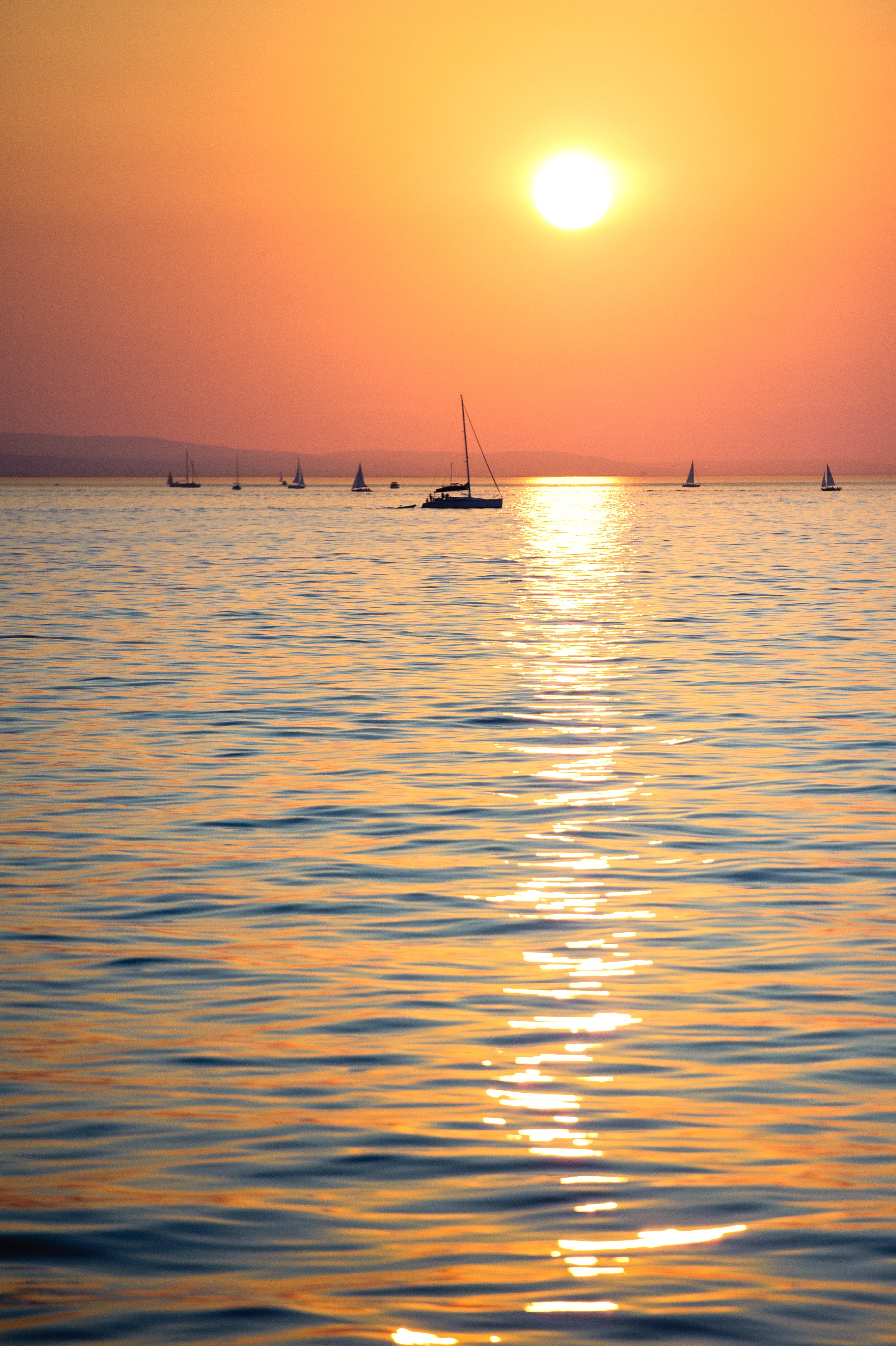 Download mobile wallpaper Sunset, Horizon, Sun, Ocean, Nature, Boats for free.