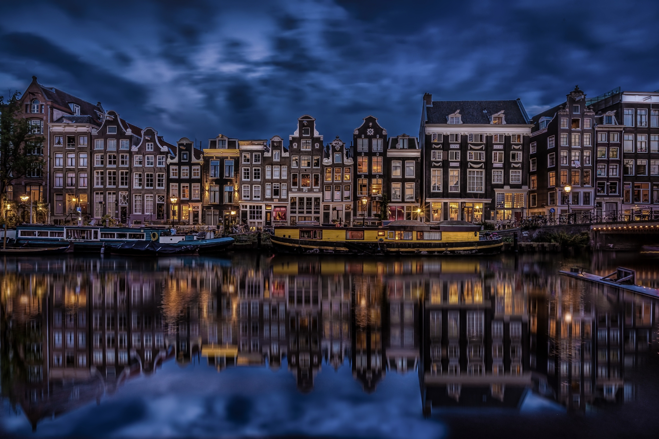 Download mobile wallpaper Cities, Night, Reflection, Light, House, Boat, Netherlands, Amsterdam, Man Made, Canal for free.