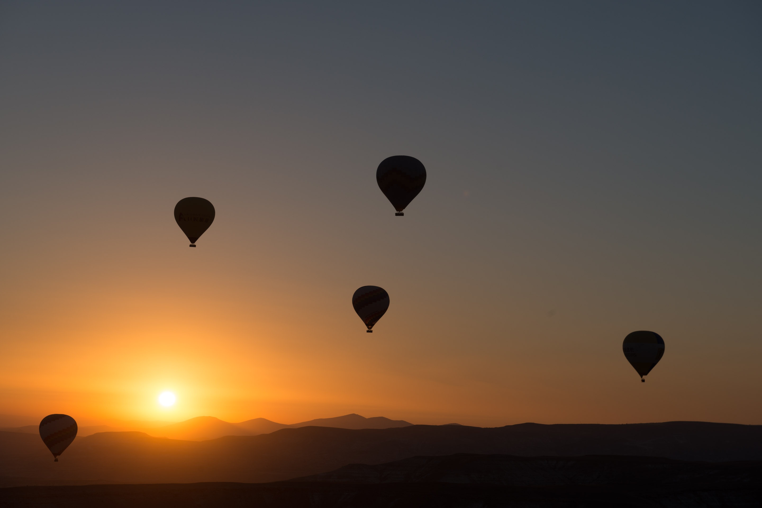 Download mobile wallpaper Sunset, Sky, Horizon, Silhouette, Vehicles, Hot Air Balloon for free.