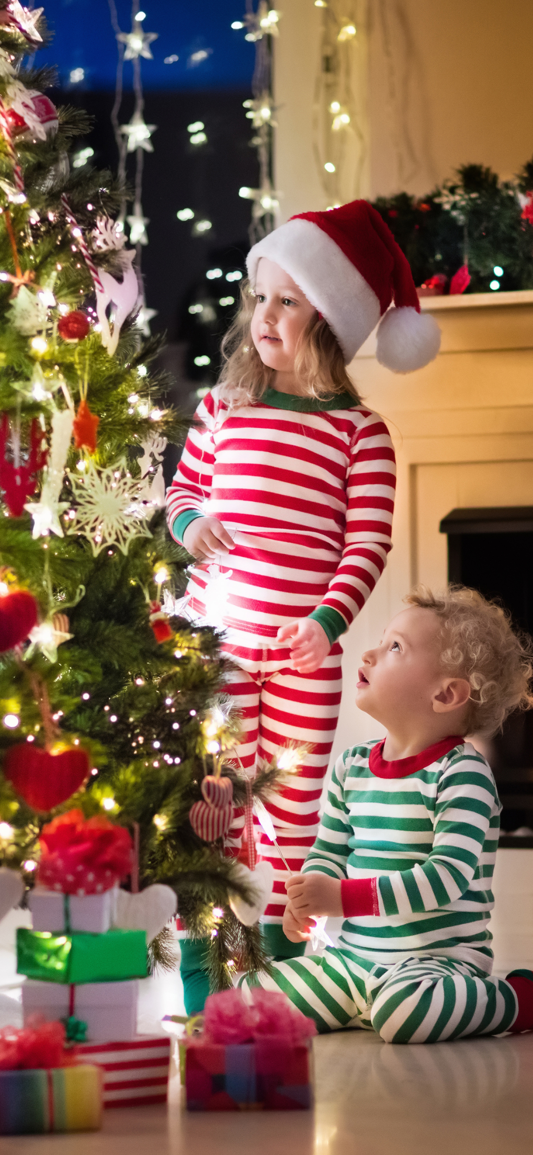 Скачати мобільні шпалери Різдво, Свято, Подарунок, Дитина, Маленька Дівчинка, Капелюх Діда Мороза, Маленький Хлопчик безкоштовно.