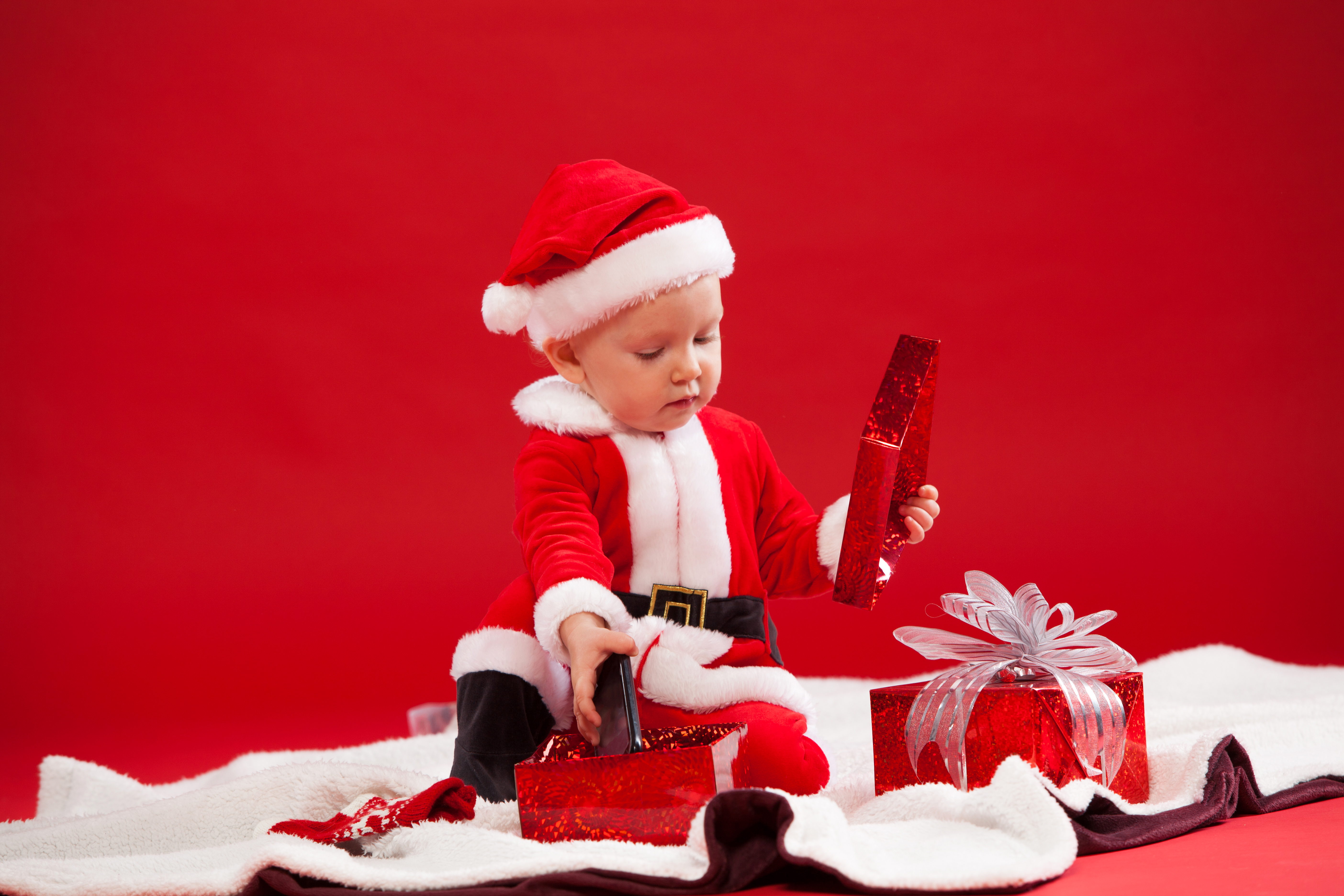Скачать картинку Красный, Рождество, Малыш, Фотографии, Подарки, Шляпа Санты в телефон бесплатно.