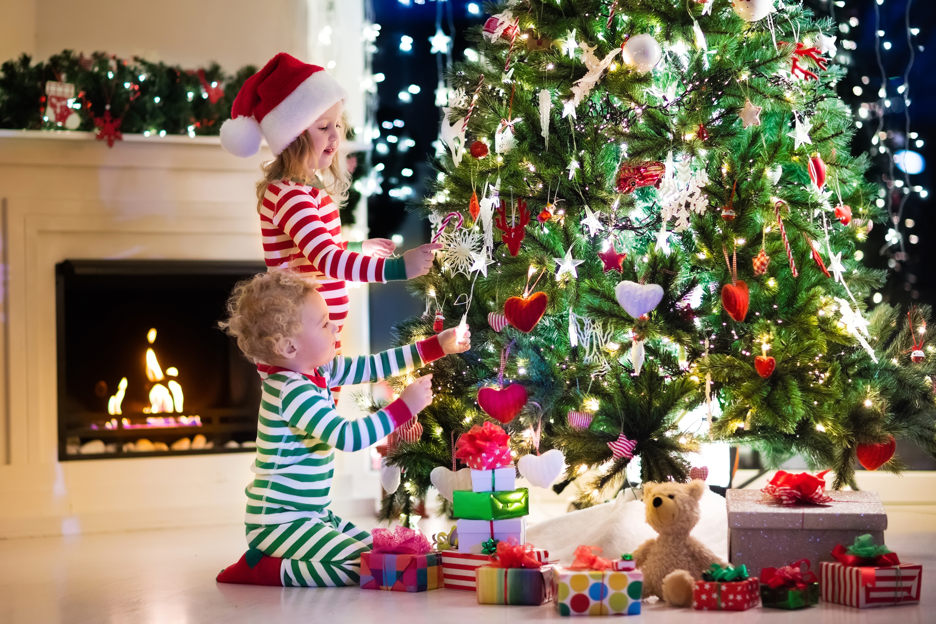 Handy-Wallpaper Feiertage, Weihnachten, Geschenk, Kind, Weihnachtsschmuck, Weihnachtsbaum, Kamin, Weihnachtsmütze kostenlos herunterladen.