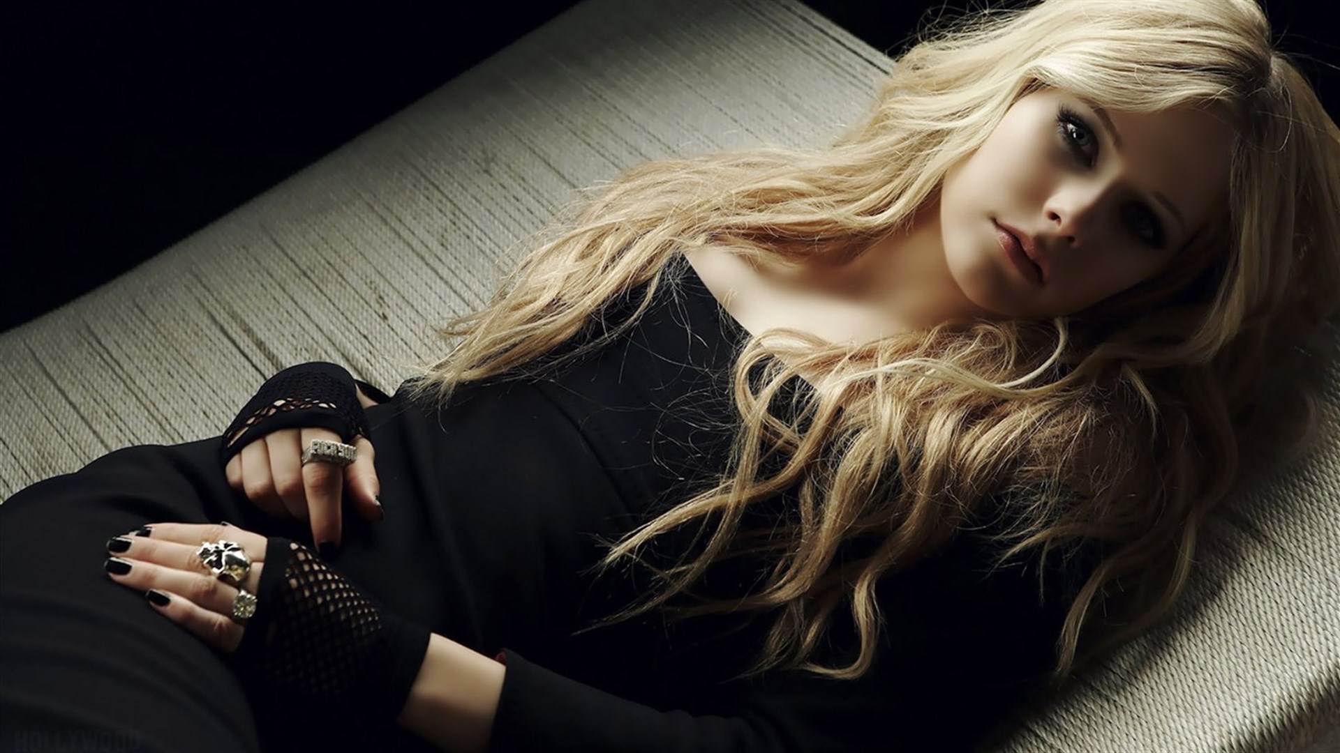 Download mobile wallpaper Music, Avril Lavigne, Singer, Blonde, Blue Eyes, Long Hair, Black Dress, Lying Down for free.