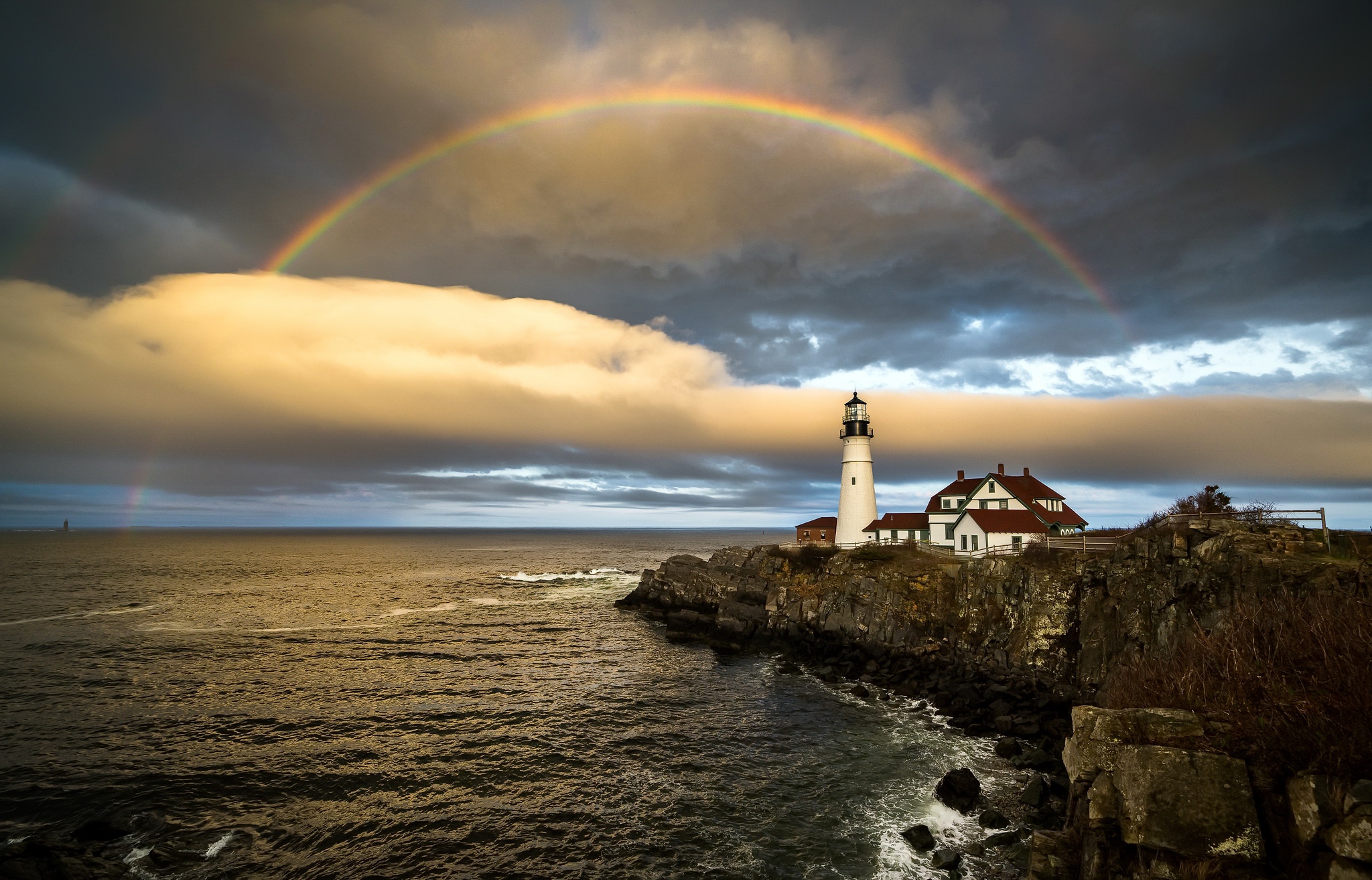 Download mobile wallpaper Sky, Rainbow, Building, Horizon, Coast, Ocean, Lighthouse, Cloud, Man Made for free.