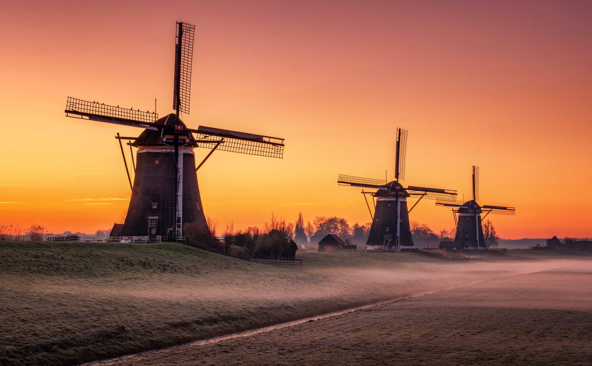 Download mobile wallpaper Sunset, Sky, Building, Windmill, Man Made for free.