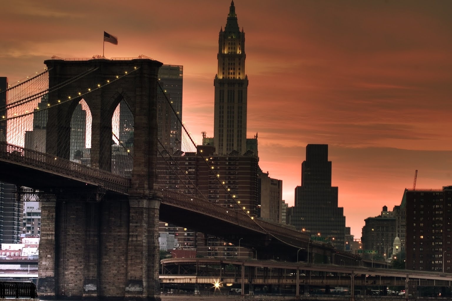 Скачати мобільні шпалери Міста, Захід, Хмарочоси, Міст, Світло, Світлий, Нью Йорк безкоштовно.