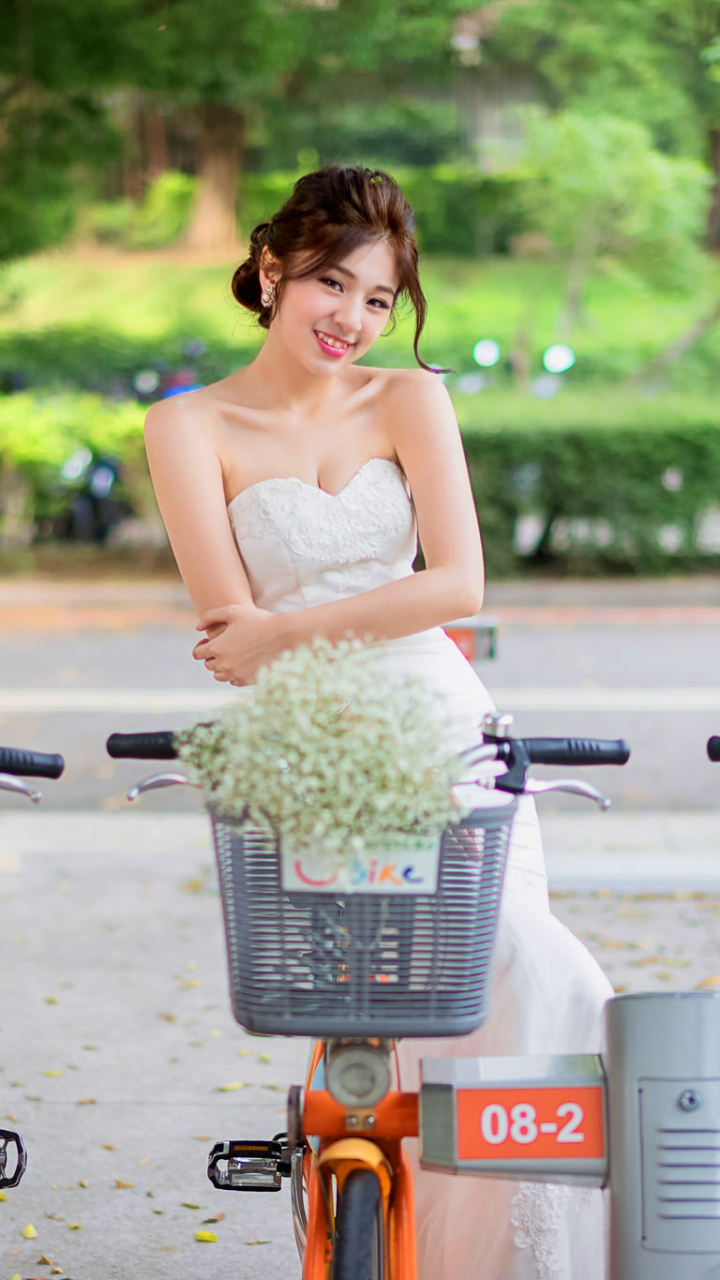 Download mobile wallpaper Smile, Bicycle, Brunette, Oriental, Bride, Women, Wedding Dress for free.