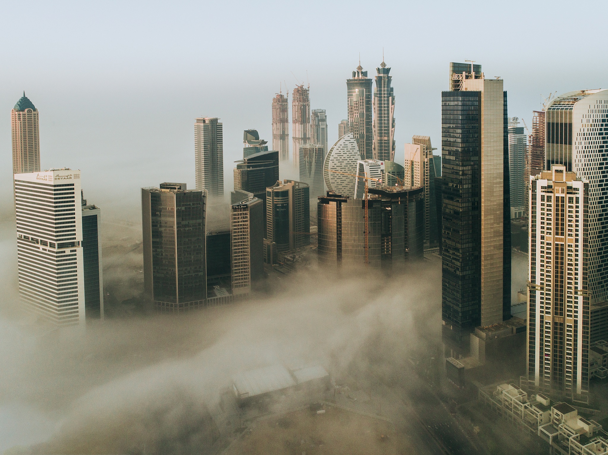 Baixar papel de parede para celular de Cidades, Cidade, Arranha Céu, Dubai, Construção, Emirados Árabes Unidos, Feito Pelo Homem, Neblina gratuito.