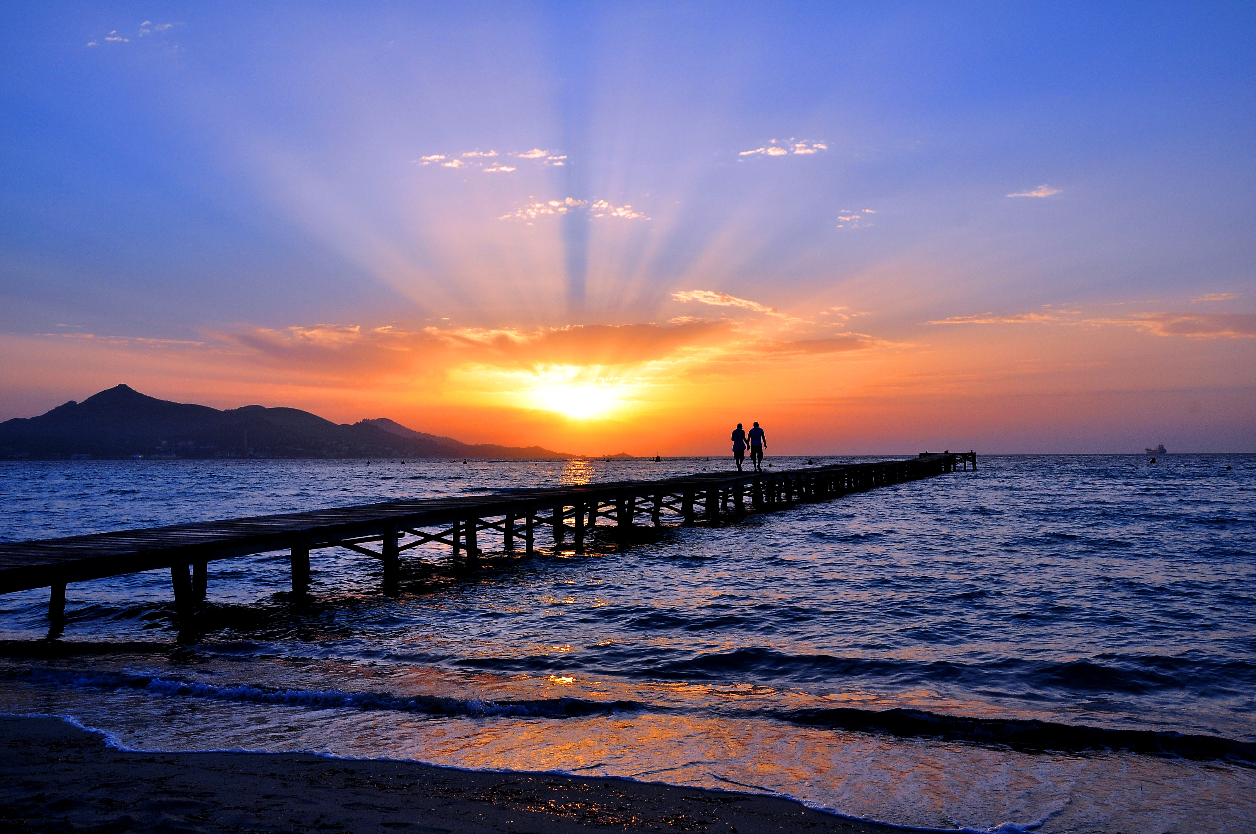 Download mobile wallpaper Sunset, Sky, Sea, Horizon, Pier, Couple, Ocean, Man Made for free.