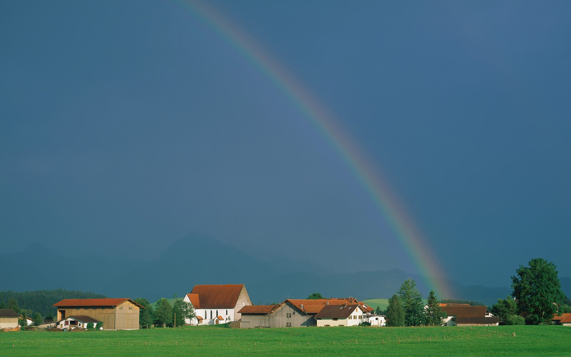 Download mobile wallpaper Village, Grass, Rainbow, Earth, Sky for free.