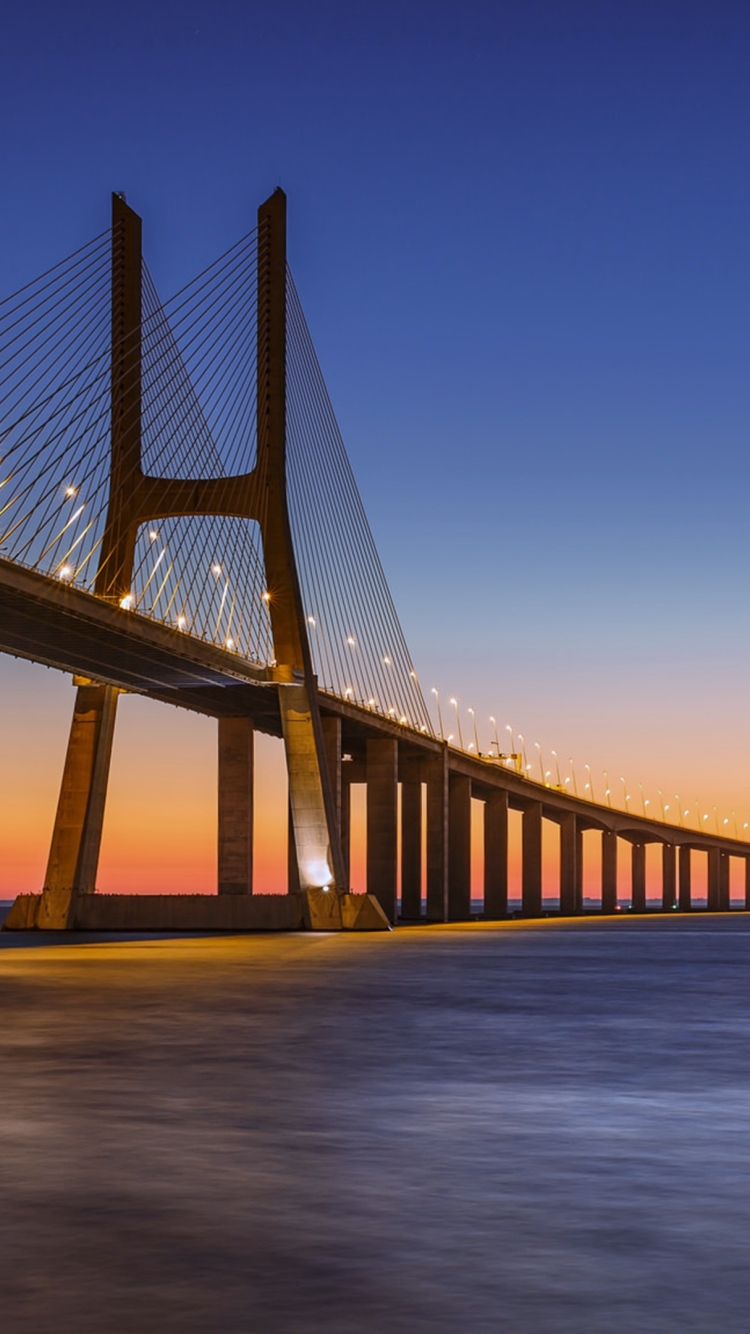 Скачать картинку Мосты, Закат, Море, Мост, Португалия, Сделано Человеком, Закат Солнца, Мост Васко Да Гама в телефон бесплатно.
